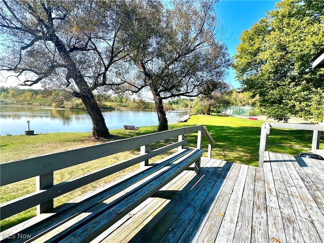 deck with a yard and a water view