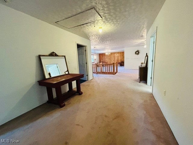 hallway with a textured ceiling and carpet flooring