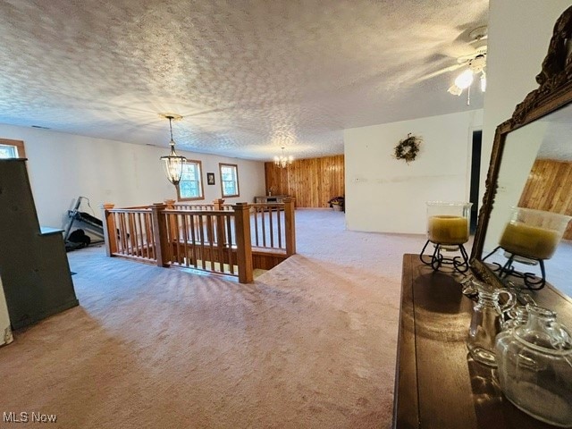 interior space with a textured ceiling, carpet floors, and a chandelier