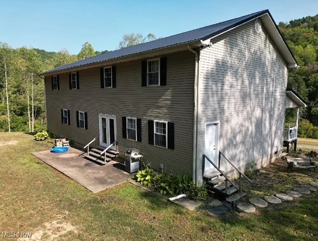 rear view of house featuring a patio area and a yard
