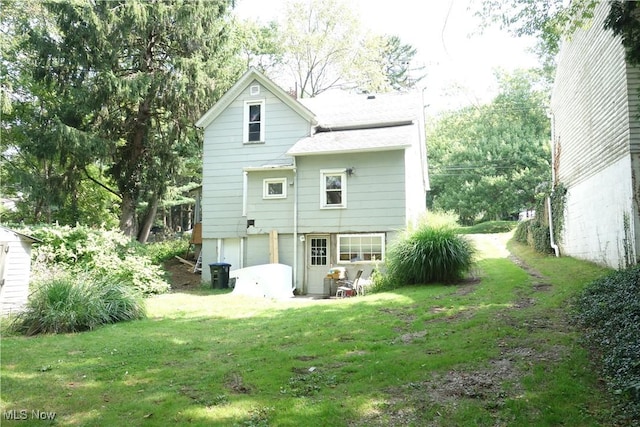 rear view of property with a lawn