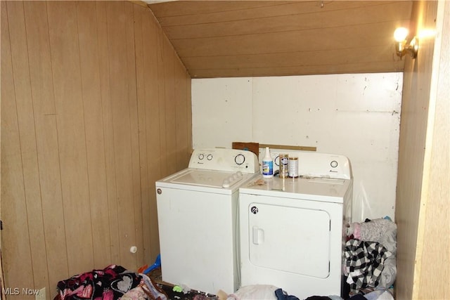 washroom featuring washer and dryer, laundry area, and wooden walls