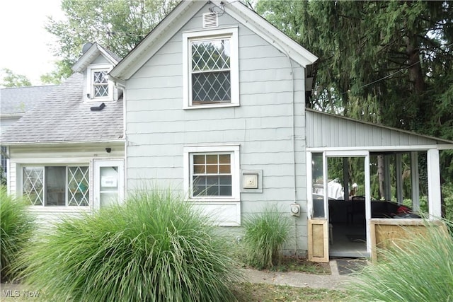 view of home's exterior with roof with shingles