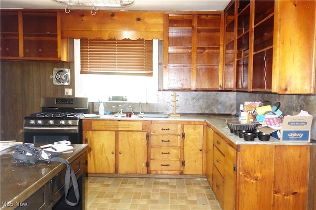 kitchen featuring gas range, visible vents, light countertops, and backsplash