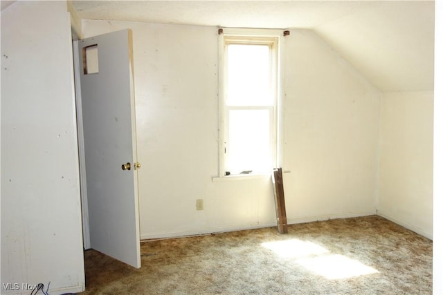 bonus room with vaulted ceiling and carpet flooring