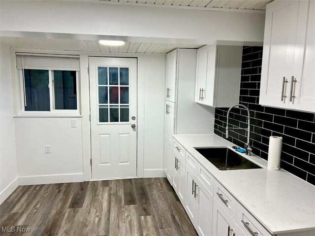 kitchen featuring light stone counters, dark wood-type flooring, white cabinets, and tasteful backsplash