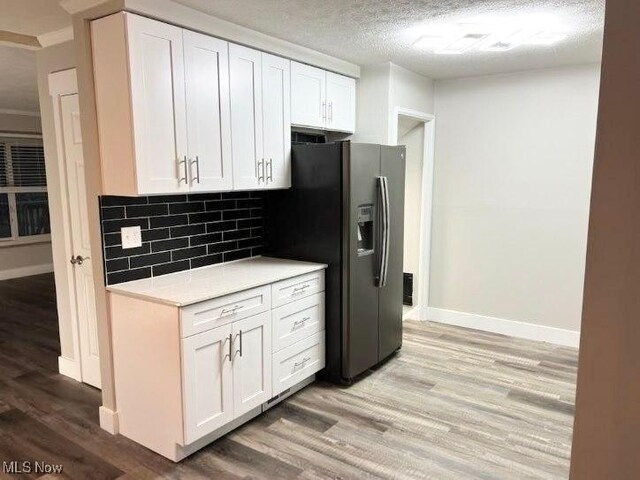 kitchen with hardwood / wood-style flooring, decorative backsplash, and white cabinets