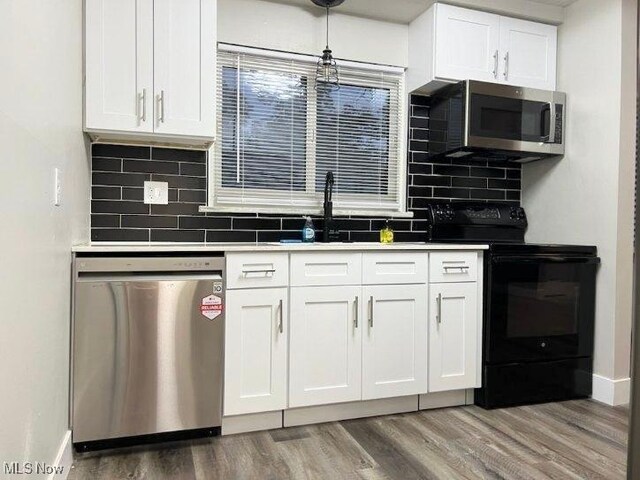 kitchen featuring white cabinetry, appliances with stainless steel finishes, wood-type flooring, and decorative backsplash