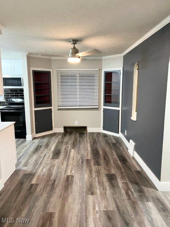 unfurnished dining area featuring ceiling fan, dark hardwood / wood-style floors, and ornamental molding