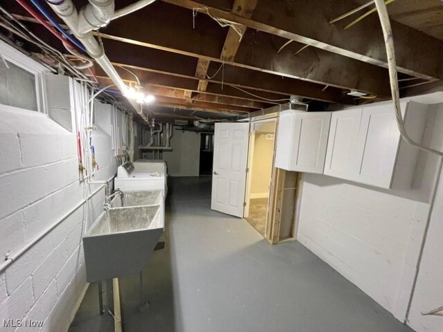 basement featuring sink and washer / dryer