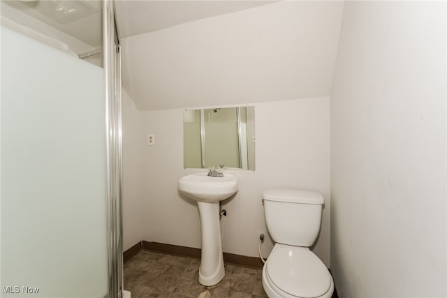 bathroom featuring toilet, vaulted ceiling, and tile patterned floors