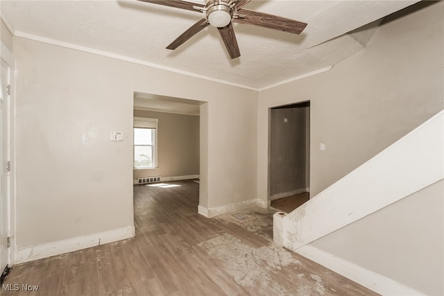 spare room with hardwood / wood-style flooring, ornamental molding, a textured ceiling, and ceiling fan