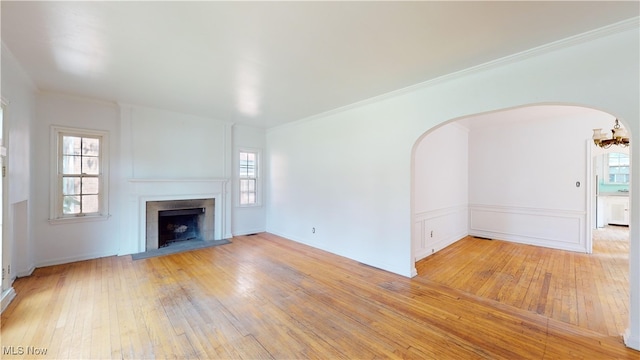 unfurnished living room with ornamental molding and light wood-type flooring