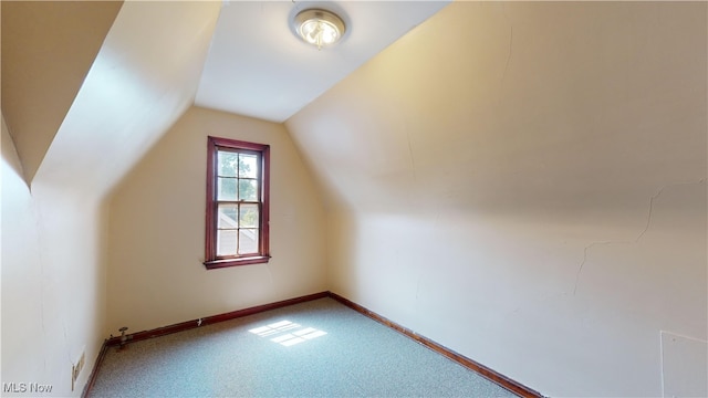 additional living space with carpet flooring and vaulted ceiling