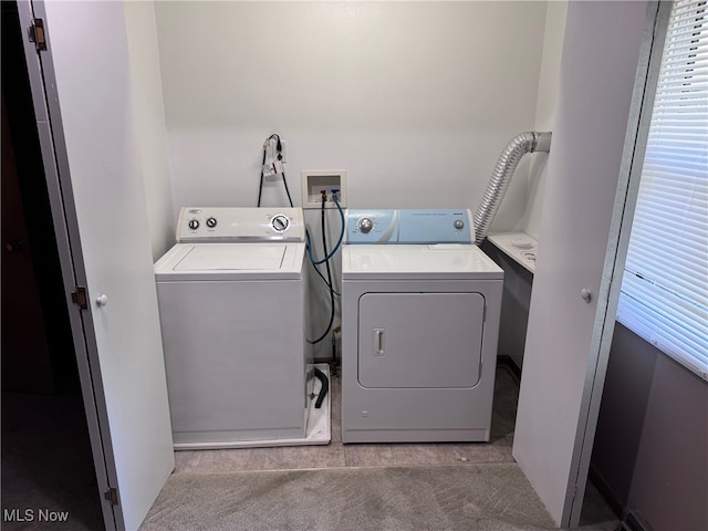 laundry room with separate washer and dryer and light carpet