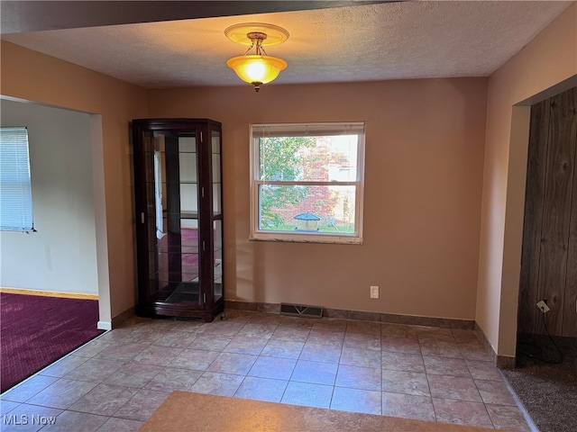 unfurnished bedroom with a textured ceiling and light colored carpet