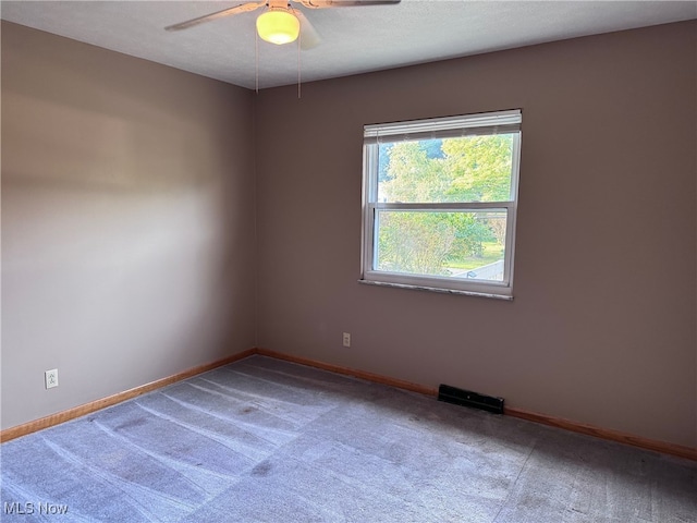 empty room with ceiling fan and carpet