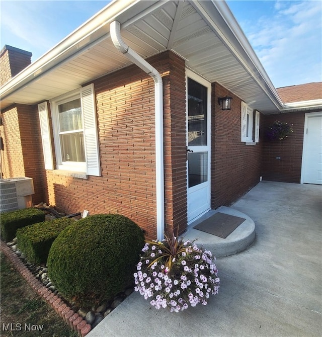 view of property exterior with a garage and central AC unit