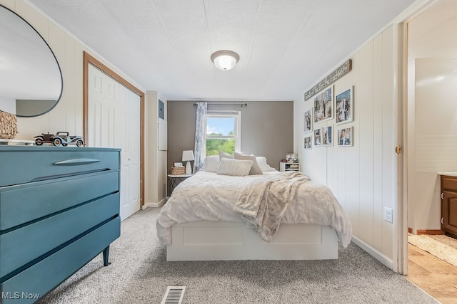 bedroom featuring light colored carpet and a closet