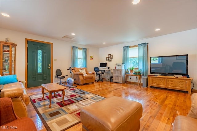 living area featuring a wealth of natural light, recessed lighting, and light wood-style flooring