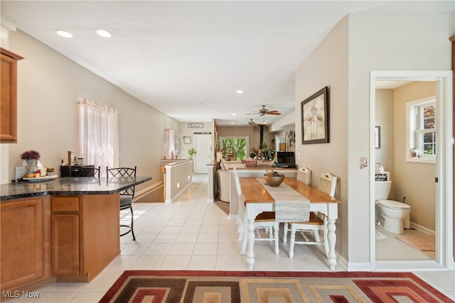 kitchen with ceiling fan, light tile patterned floors, and a kitchen bar