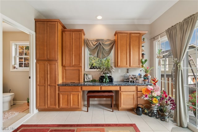 kitchen featuring light tile patterned floors and dark stone counters