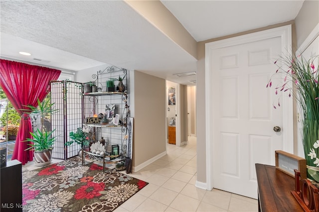 tiled entryway featuring a textured ceiling