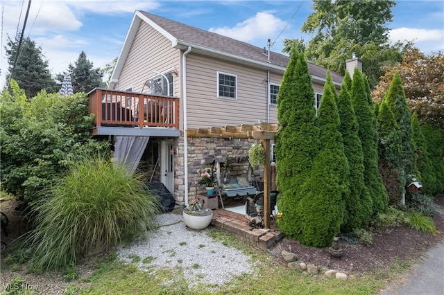 rear view of house with a wooden deck and a pergola