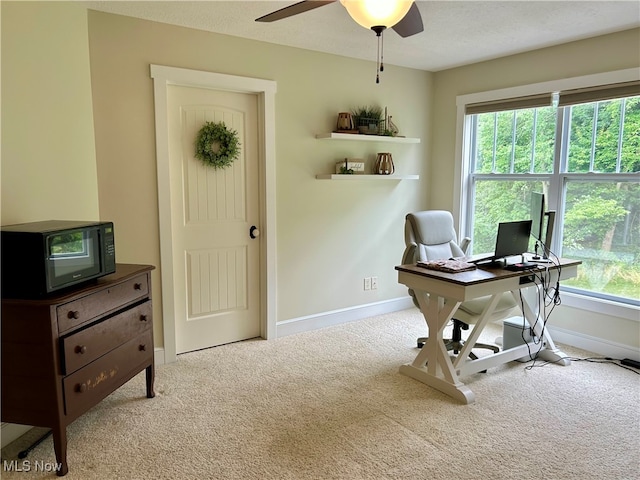 carpeted office featuring a textured ceiling and ceiling fan