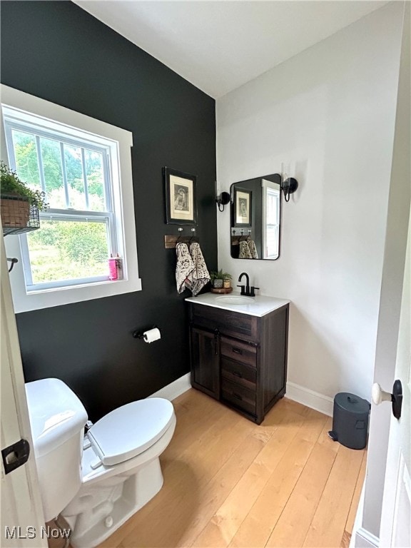 bathroom featuring wood-type flooring, toilet, and vanity