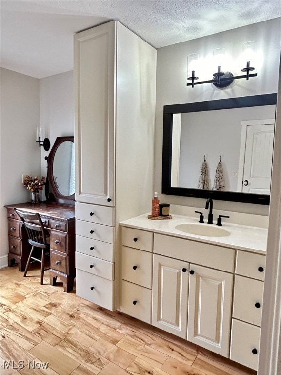 bathroom featuring hardwood / wood-style floors, a textured ceiling, and vanity