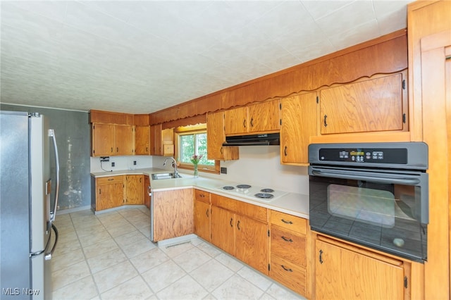 kitchen with white electric cooktop, oven, sink, and stainless steel fridge