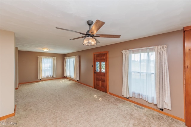 foyer entrance with light carpet and ceiling fan