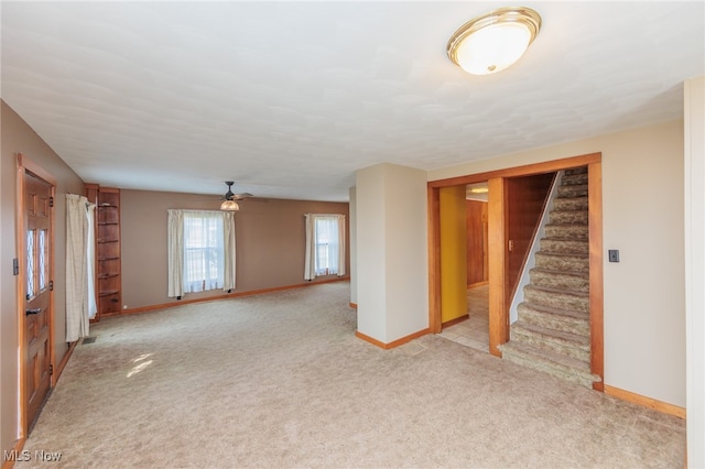 unfurnished living room with light colored carpet and ceiling fan