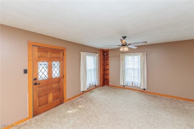 entrance foyer with carpet and ceiling fan