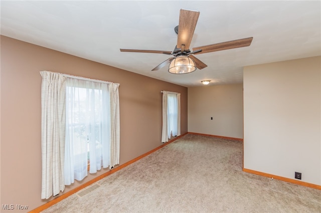 spare room with ceiling fan and light colored carpet