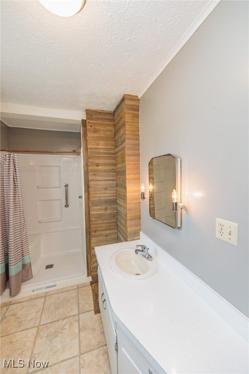 bathroom featuring a textured ceiling, ornamental molding, vanity, a shower with curtain, and tile patterned floors