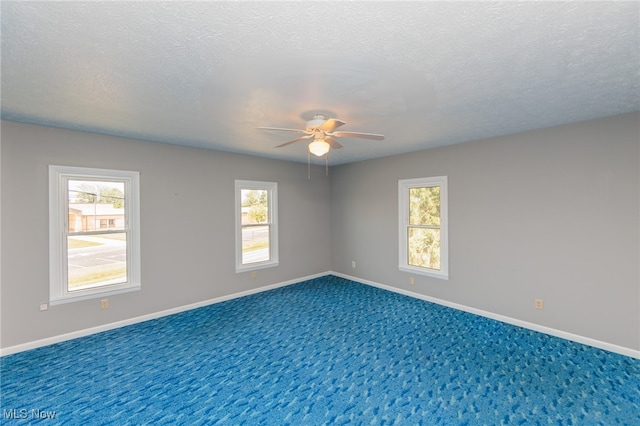 empty room with ceiling fan, a textured ceiling, and carpet floors