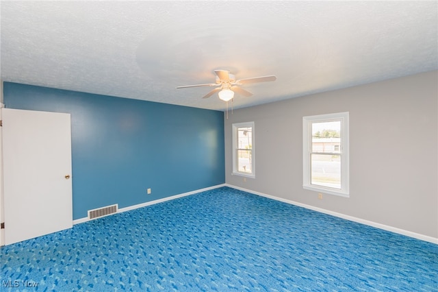 carpeted spare room featuring ceiling fan and a textured ceiling