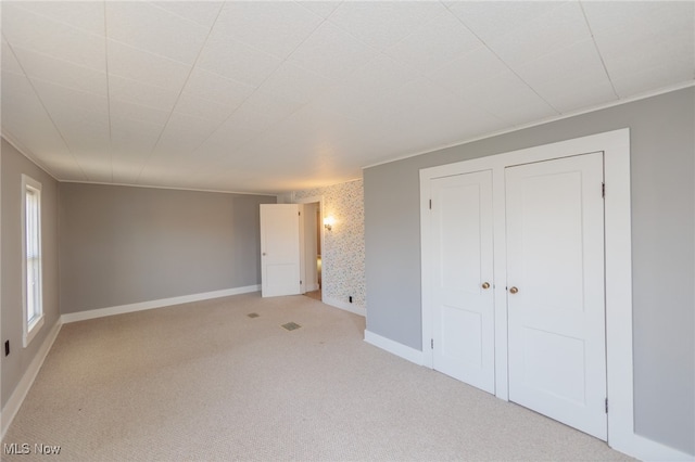 unfurnished bedroom with crown molding and light colored carpet