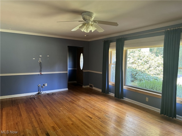 spare room featuring hardwood / wood-style floors, ceiling fan, crown molding, and a healthy amount of sunlight