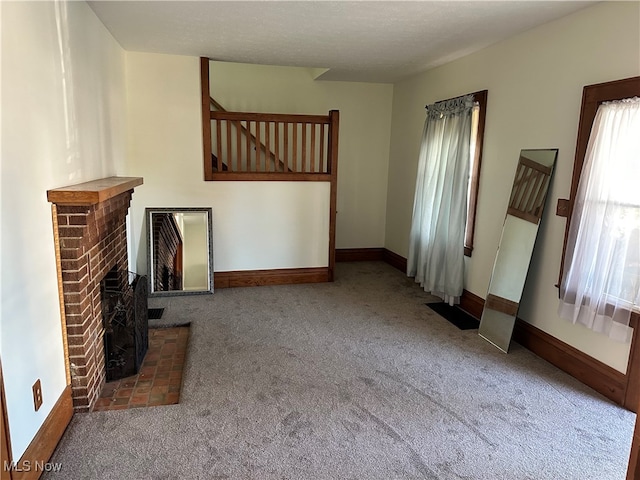 unfurnished living room featuring a fireplace and carpet floors