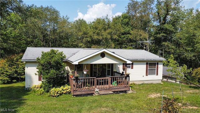 back of property with a lawn and a wooden deck