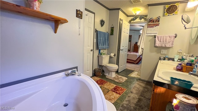 bathroom with a textured ceiling, a bathtub, ceiling fan, vanity, and toilet