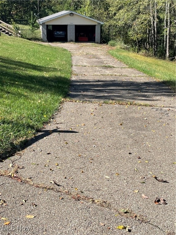 view of outdoor structure with a garage and a lawn