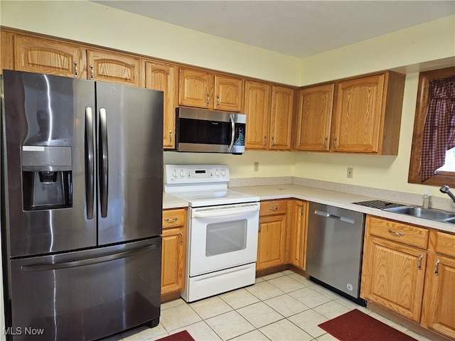 kitchen with sink, stainless steel appliances, and light tile patterned flooring