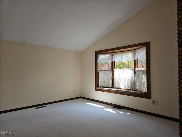 empty room featuring lofted ceiling and light colored carpet