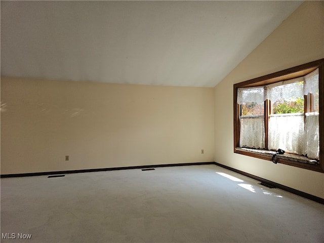 spare room with lofted ceiling and carpet flooring