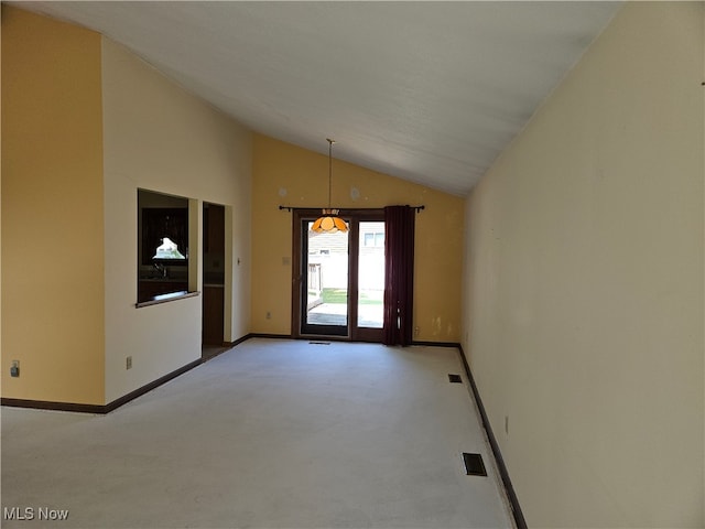 carpeted empty room featuring vaulted ceiling