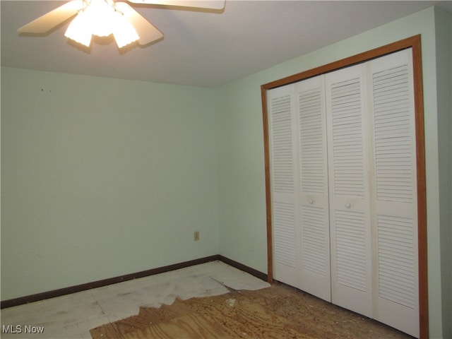 unfurnished bedroom with ceiling fan and a closet